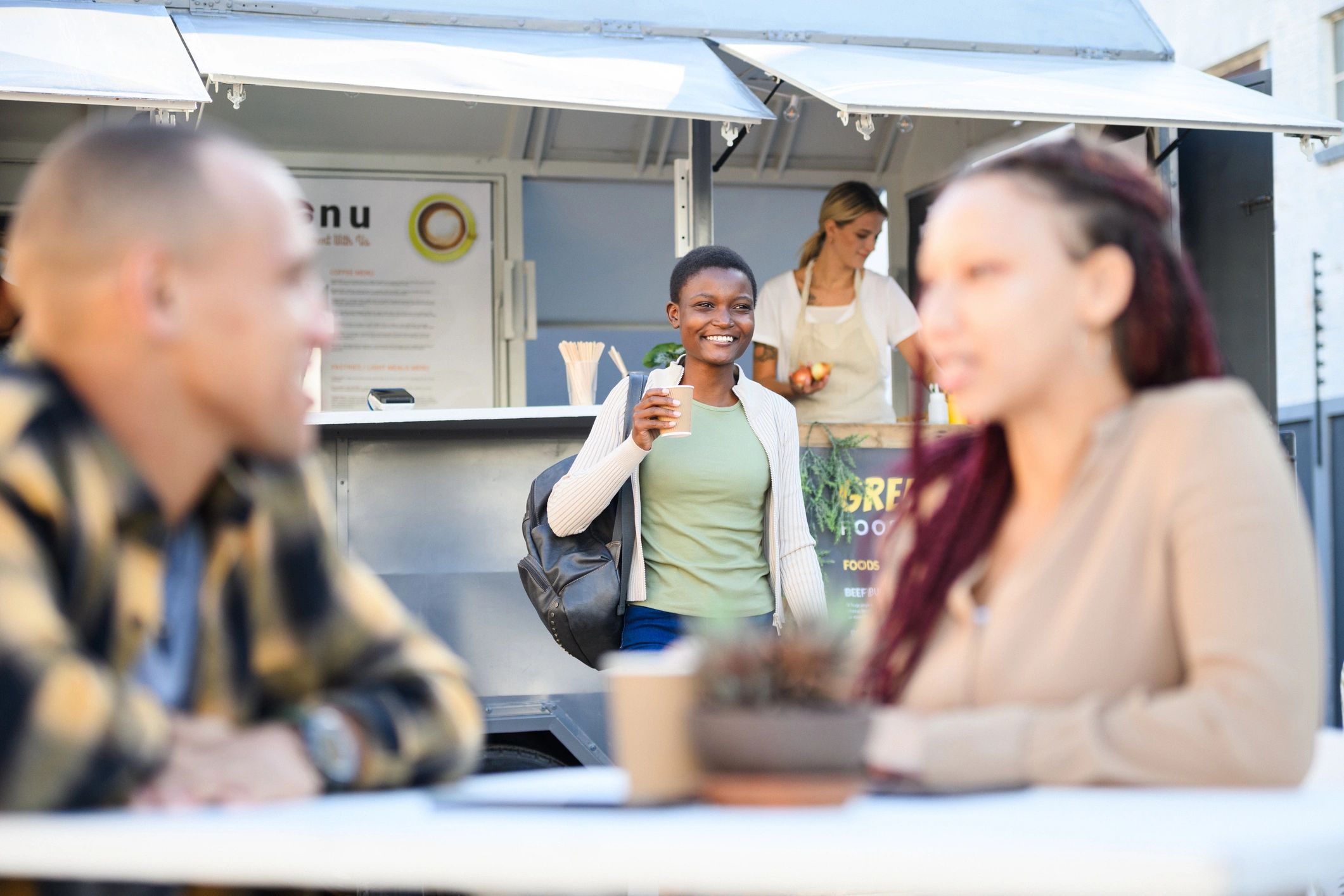 Young Generation Z African woman walking to table with coffee